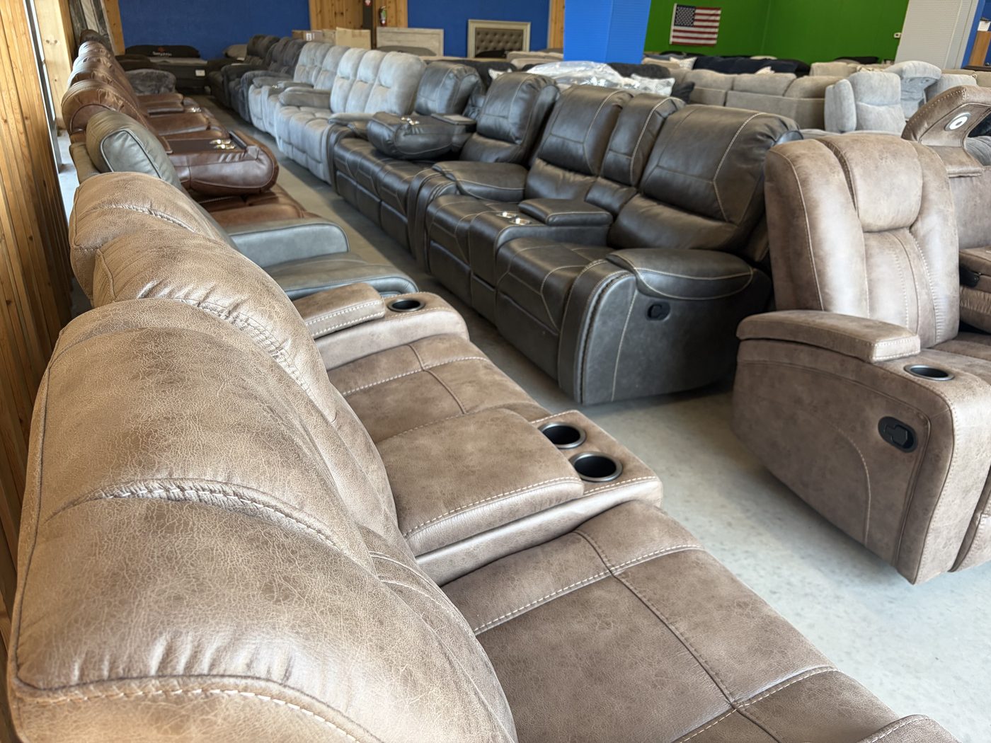 Rows of reclining sofas and loveseats with cup holders